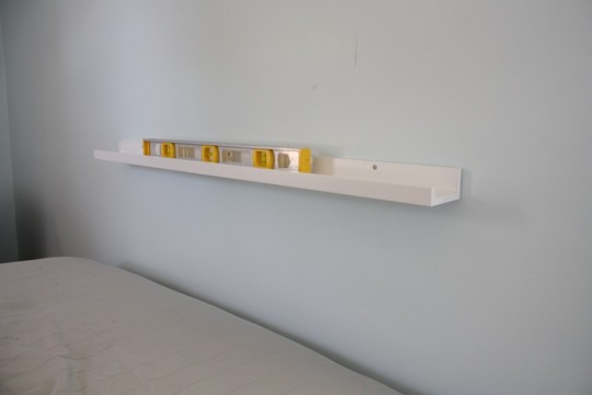 A floating IKEA shelf to support the new guest room headboard.