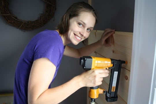 Nailing in the shiplap board by board, attaching methodically about 1-2" from the bottom of each panel. 