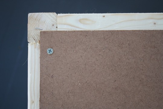 Attaching the backer board to the ottoman frame.