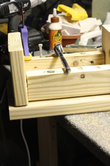 Installing the lag bolts into the bottom of the step stool to attach the top.